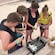 A group of young people on a beach checking tubes of water with P H sticks